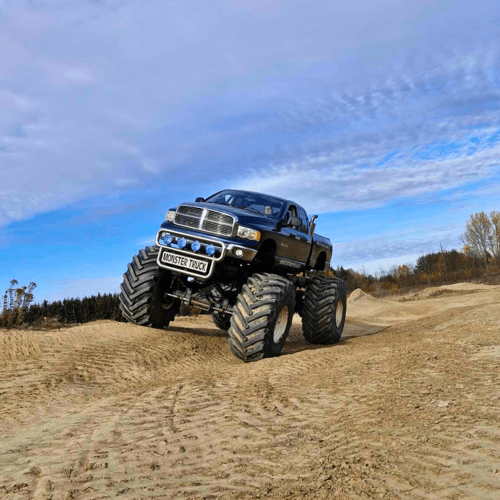 W samym sercu piaszczystego terenu, potężny monster truck ze zdumiewającymi, ogromnymi oponami wznosi się na wzniesienie, oferując emocjonujące atrakcje dla wszystkich odwiedzających w Gassy, niedaleko Warszawy.
