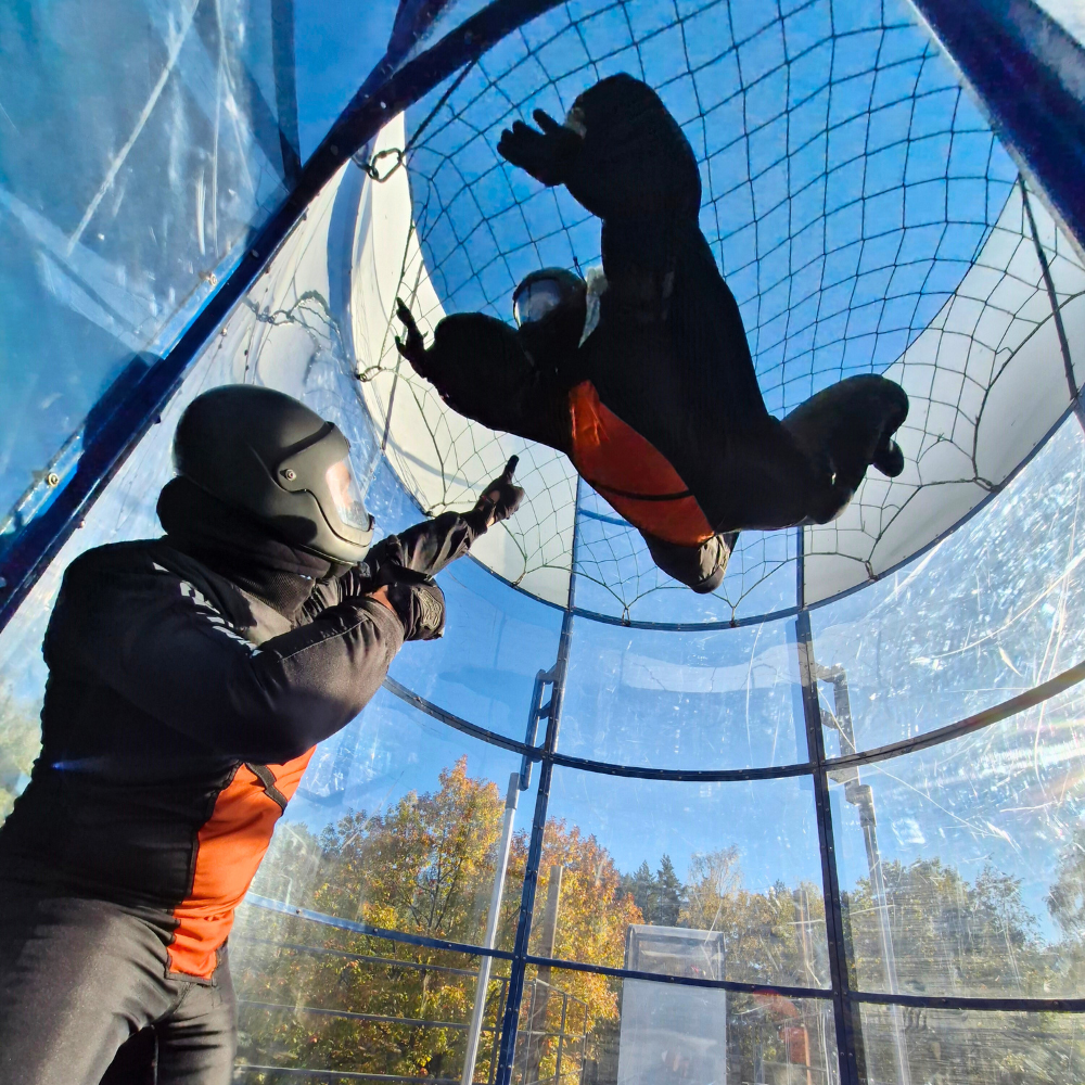 Uczestnik podczas lotu w tunelu aerodynamicznym pod opieką instruktora