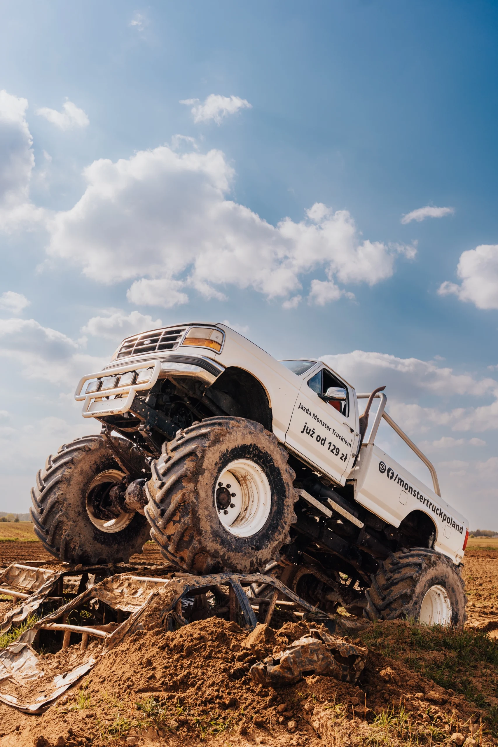 Biały Monster Truck podczas pokonywania terenowej przeszkody